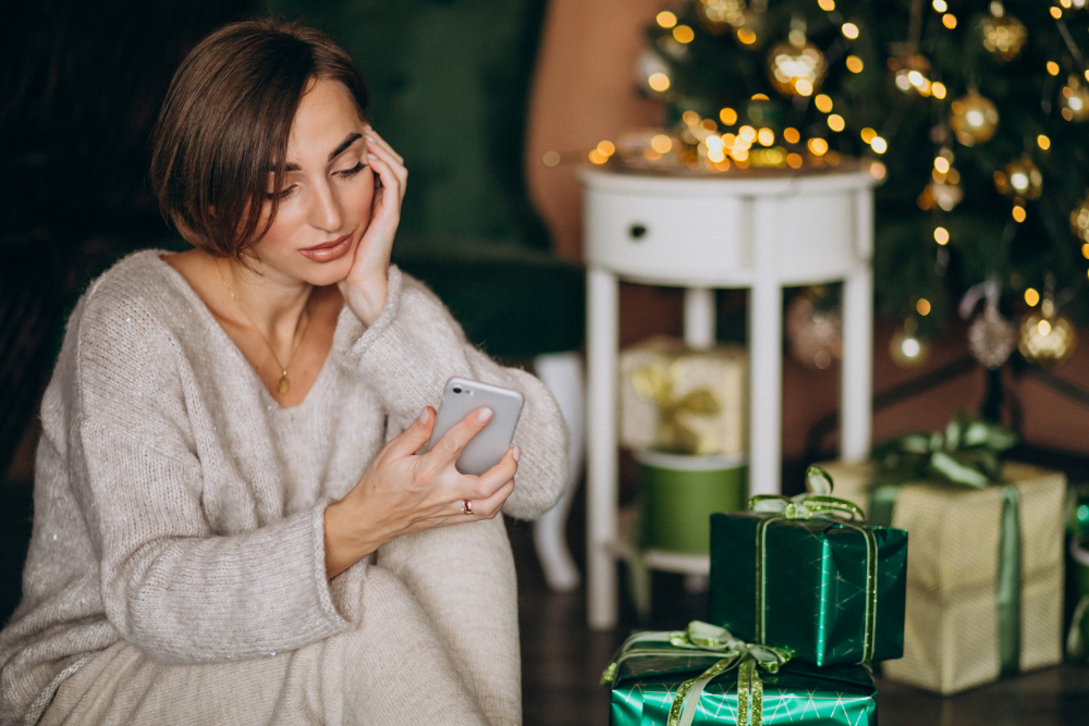 Mulher ansiosa com o final de ano, olhando para o celular