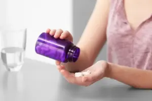Medicamentos para fibromialgia sendo colocados na mão antes do uso.
